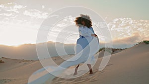 Girl dancer waving fluttering cloth performing contemporary dance in desert.