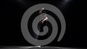 Girl dances flamenco. Black background.