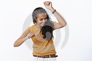 Girl dancing carefree not giving care if anyone watching having fun showing cool dance moves as shaking body and raising