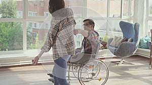 Girl dancing with a disabled man in a wheelchair.Slow mo