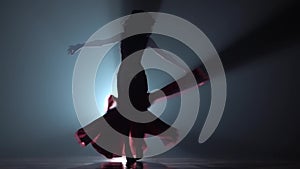 Girl dancing in dress on black smoke background. Sihouette. Slow motion