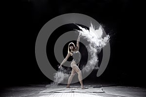 Girl dancing with a flour on black background.