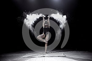 Girl dancing with a flour on black background.