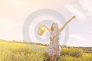 Girl dancing among flowers in a sunny day