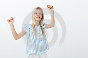 Girl dancing on friends party, having fun. Indoor portrait of positive cheerful bright female child with fair hair