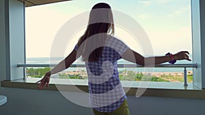 Girl dancing lambada on the balcony of the hotel overlooking the sea or ocean.
