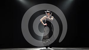 Girl dancing a Spanish incendiary dance. Black background. Llight from behind. Slow motion