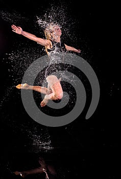 Girl dancing water jumping black background