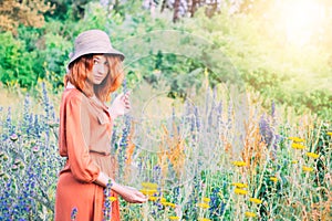 Girl on dandelion on green field.