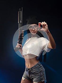 The girl on a dark background with a shotgun