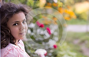 Girl with dark hair sitting on the doorstep in the garden