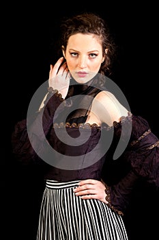 Girl in dark Victorian dress with hand besides her eyes