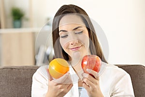 Girl deciding between two fruits photo