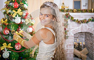 Girl decorates Christmas tree photo