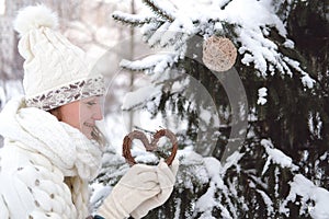 The girl decorates the Christmas tree with toys in the winter forest or park. Concept - Christmas vacations and holidays