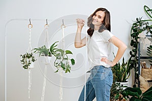 A girl decorates the interiors with plants and makes beautiful macrame