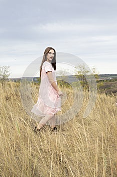 Girl in a delicate dress walks in nature