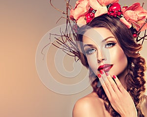 Girl with delicate wreath from flowers, fruits and twigs on her head.