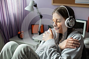 A girl delighted with new songs. Listens to music on wireless headphones.