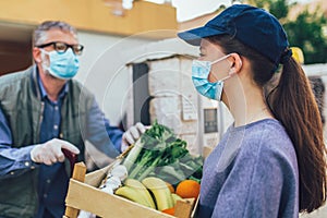 Girl is delivering some groceries to an elderly person, during the epidemic coronovirus, COVID-19