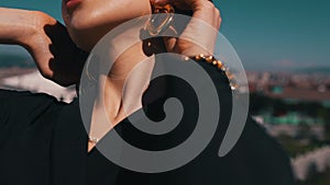 girl demonstrates earrings on the background of the city