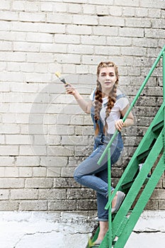 The girl makes preparing for painting a wooden surface gazebo, fence photo