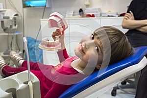 A girl in a dentist office is showing her jaws. Medicine, dentistry and health care