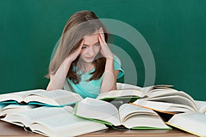 Girl At Desk With Many Books