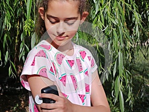 Girl with diabetes checks glucose level in blood with device for continuous glucose monitoring Ã¢â¬â CGM. photo