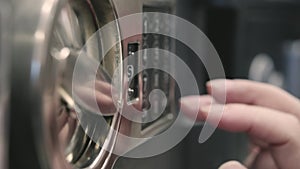 Girl dials a code on the safe panel and opens it. Close up shot