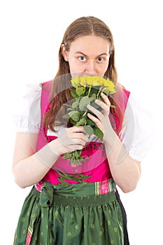 Girl in dirndl with bunch of yellow roses