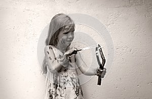 A girl in a dirty dress shoots from a slingshot