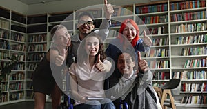 Girl with disability sit in wheelchair pose with groupmates indoors