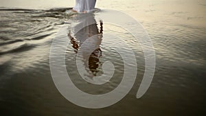 Girl disappearing into the sea at sunset