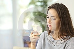 Girl disgusted looking a dietetic cookie photo