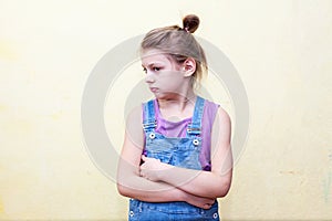 Girl with   displeased face,   crossing   arms over   chest