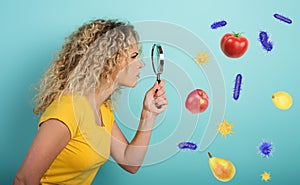 Girl is distrustful about contagion of bacteria on food. Cyan background