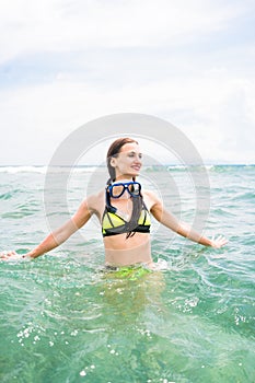 Girl with diving goggles in sea having summer vacation
