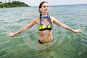 Girl with diving goggles in sea having summer vacation