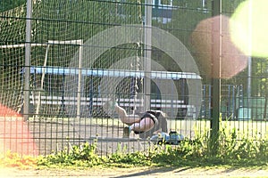 A girl does exercises at the stadium, Does the plank exercise. stands with a straight back on the elbows of the hand. Black