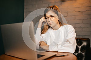 The girl does hard work at the computer, complex tasks