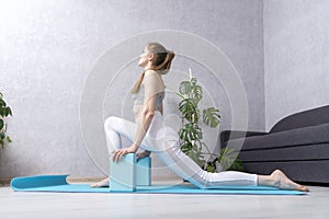 Girl does stretch using yoga foam blocks. Practice yoga at home. Morning gymnastics. Self-training