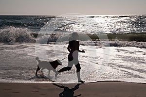 Girl and dog running on beach