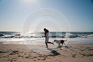 Girl and dog running on beach