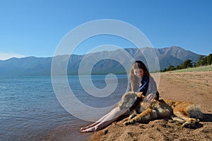 Girl with a dog on the shore of Lake Baikal