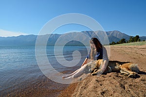 Girl with a dog on the shore of Lake Baikal