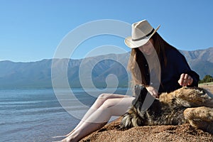 Girl with a dog on the shore of Lake Baikal