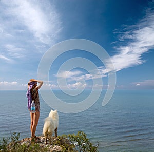 Girl and dog standing on precipice photo