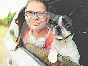 Girl and dog - terrier - looking out the open car window - friendship concept