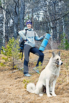 Girl and dog trekking in the forest